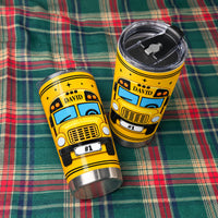 Two personalized school bus driver tumblers resting on a green and red plaid fabric background with visible lids.