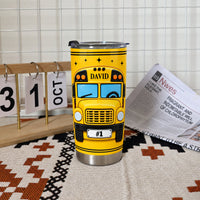 Stainless steel school bus driver tumbler with custom David name standing upright next to a desk calendar and newspaper.