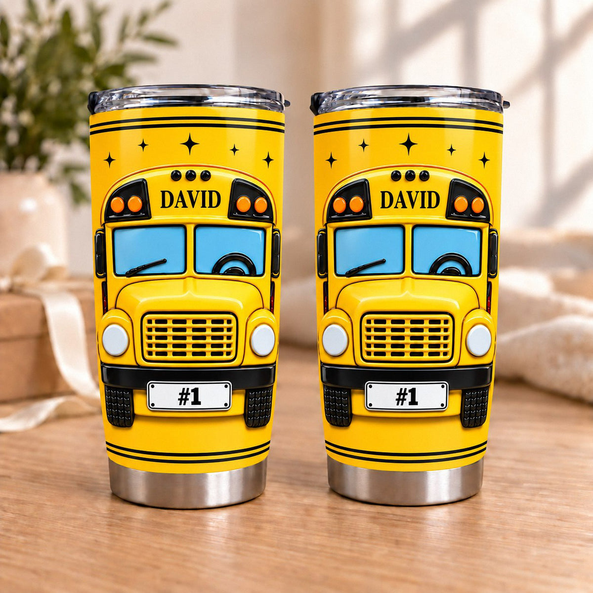 Two personalized school bus driver tumblers featuring the name DAVID and a #1 license plate on a wooden table.