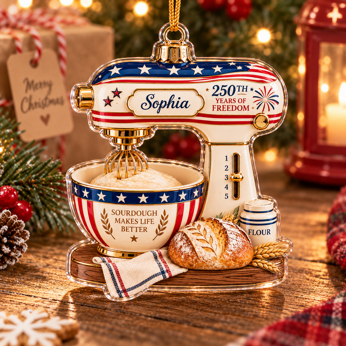 Patriotic christmas ornament shaped like a kitchen mixer displaying Sourdough Makes Life Better text resting on a wooden