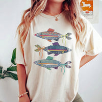 An off-white oversized t-shirt with a three denim fish graphic, styled with layered gold necklaces.