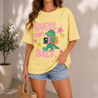 Woman wearing a yellow cotton t-shirt with an alligator graphic holding a notebook and pink text.