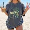 I'd Rather Be At The Lake Shirt Graphic T-Shirt For Lake Day Girl Trip Preppy Lakecore Granola Girl Oversized Fit Crew Neck With Green Purple Canoe Illustration Typography Print Retro Summer Vacation Boating Tee.