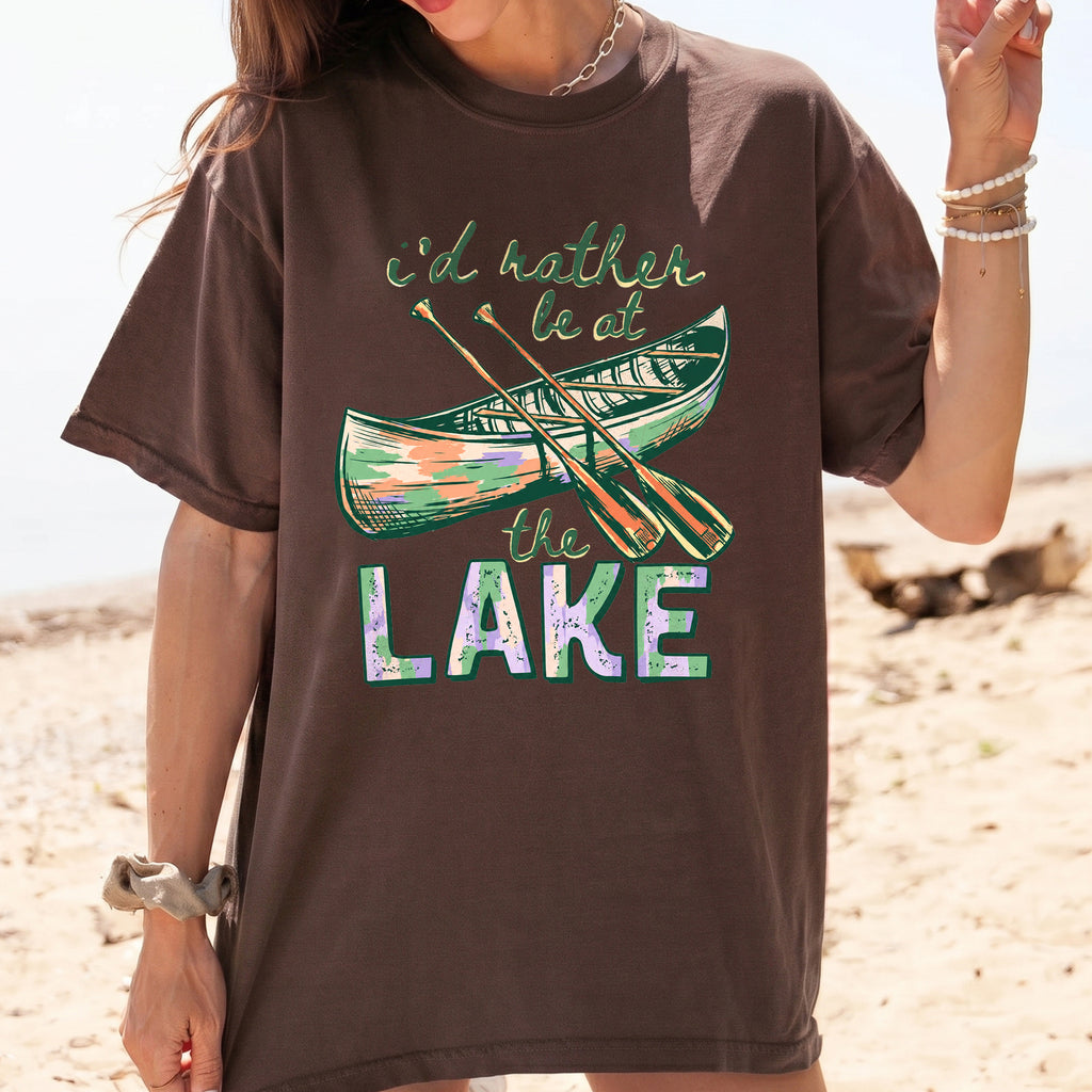 I'd Rather Be At The Lake Shirt Graphic T-Shirt For Lake Day Girl Trip Preppy Lakecore Granola Girl Oversized Fit Crew Neck With Green Purple Canoe Illustration Typography Print Retro Summer Vacation Boating Tee.