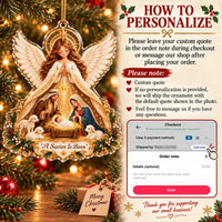 Instruction card showing how to personalize the A Savior Is Born ornament alongside the hanging acrylic decor on a wooden