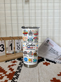 A Year to Remember Tumbler on a patterned mat beside a calendar and newspaper.