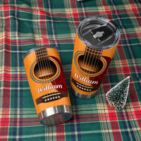Personalized acoustic guitar travel mug and tumbler with lid resting on a green and red plaid blanket with mini tree.