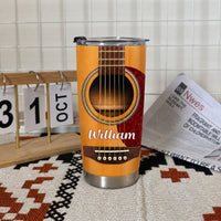 Custom guitar travel mug sitting on a patterned rug next to a desk calendar showing October 31 and an open newspaper.