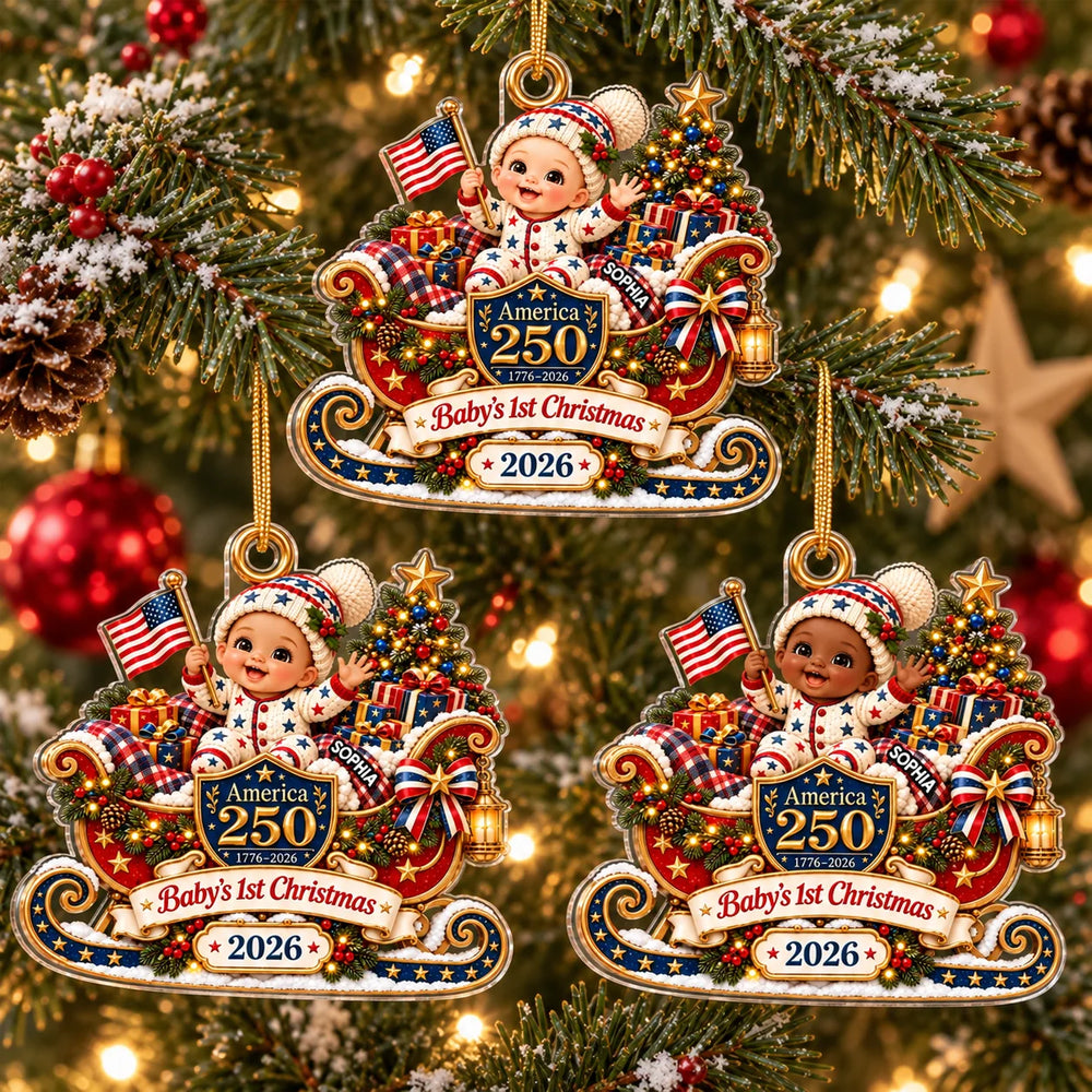 Three America 250 baby's first Christmas ornaments hanging on a glowing holiday tree with festive red and gold decorations.