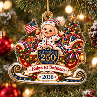 America 250 baby's first Christmas acrylic ornament hanging on a pine tree with a baby in patriotic outfit holding a US flag.