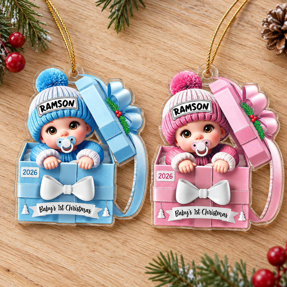 Blue and pink baby's 1st Christmas acrylic ornaments shaped like the number one on a wooden table.