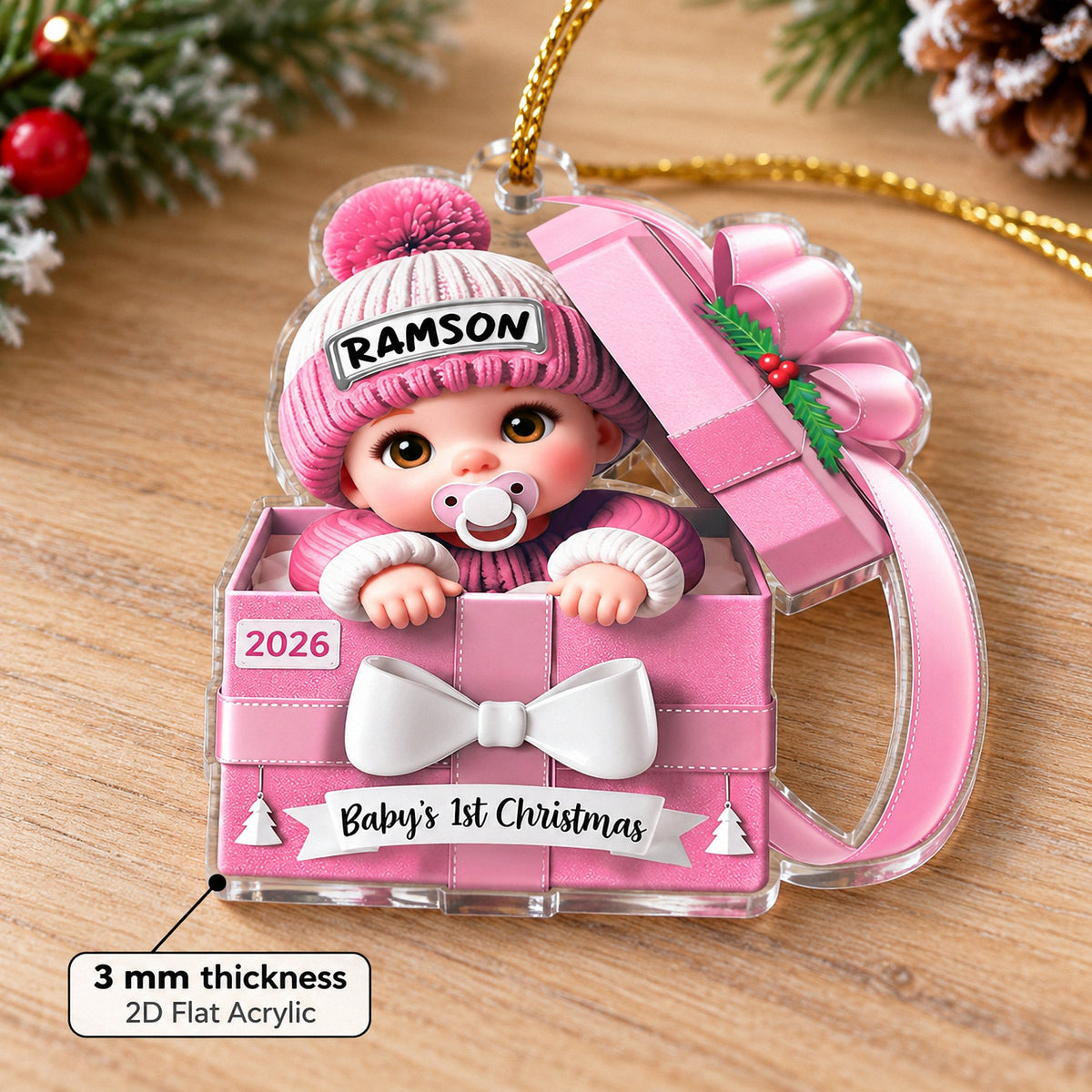 Pink acrylic number one ornament with customized name Ramson and 2026 on a wooden surface.