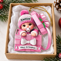 Baby's 1st Christmas ornament in pink gift box shape inside a cardboard gift box with tissue paper.