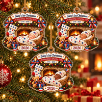 Three acrylic Baby's First Christmas ornaments hanging on a glowing tree, featuring a baby in a basket by a fireplace.