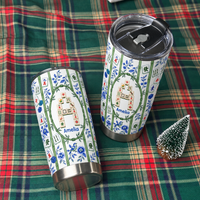 Two stainless steel travel tumblers featuring chinoiserie style designs rest on a plaid holiday blanket.