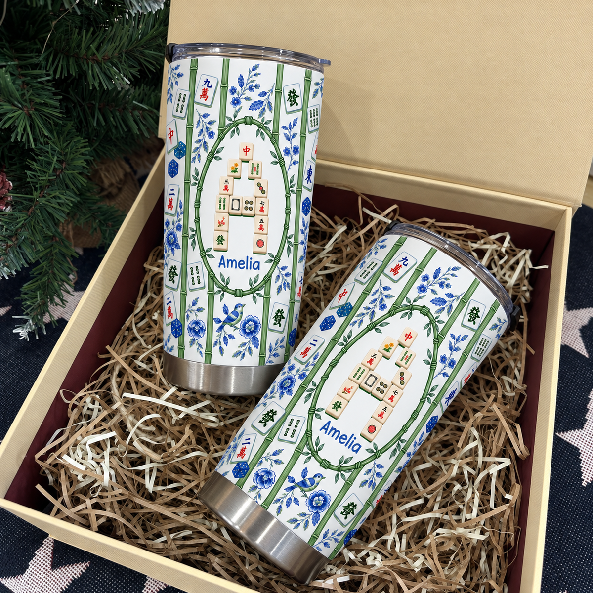 Two personalized mahjong tumblers filled with festive shredded paper inside an open gift box.