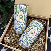 Two personalized mahjong tumblers filled with festive shredded paper inside an open gift box.