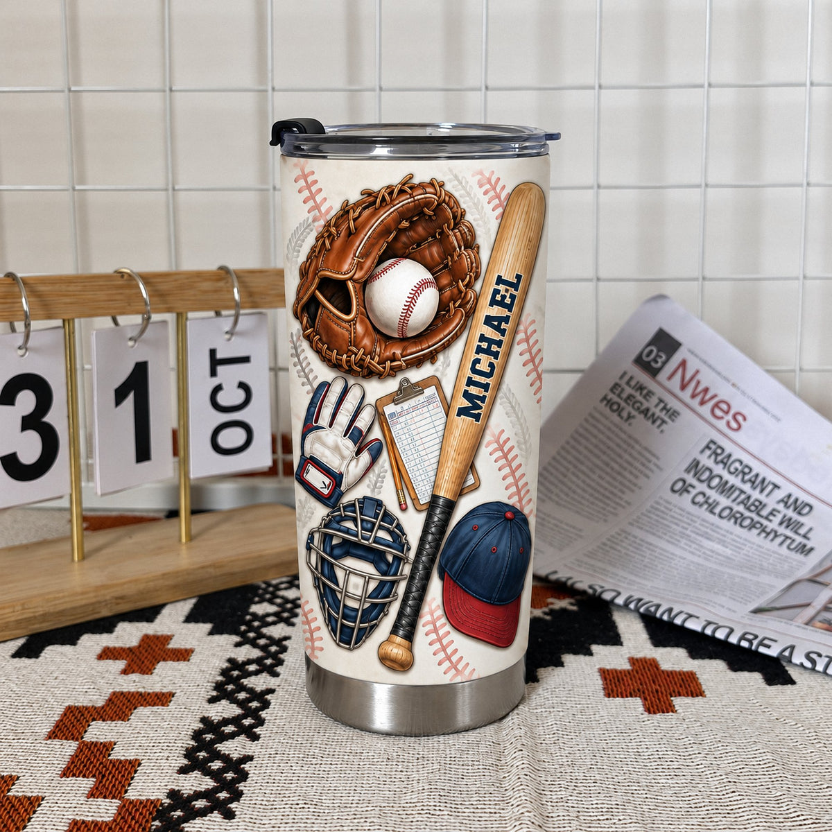 Baseball equipment tumbler displayed next to miniature calendar on patterned mat