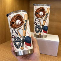 Hand holding custom baseball equipment tumbler with leather glove and bat graphic