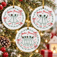 Three round ceramic Christmas ornaments hanging on a pine tree showing custom names and line art of women with wine glasses.