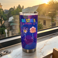 Custom insulated tumbler with purple galaxy bokeh print standing on a marble windowsill against a sunset background