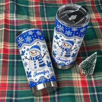 Two personalized winter tumblers on green plaid blanket with mini tree.