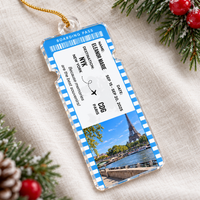 A blue boarding pass ornament with Paris Eiffel Tower design and custom traveler name on a linen surface.