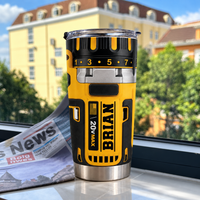 Drill theme stainless steel insulated cup with name BRIAN standing upright on a windowsill with a newspaper and building