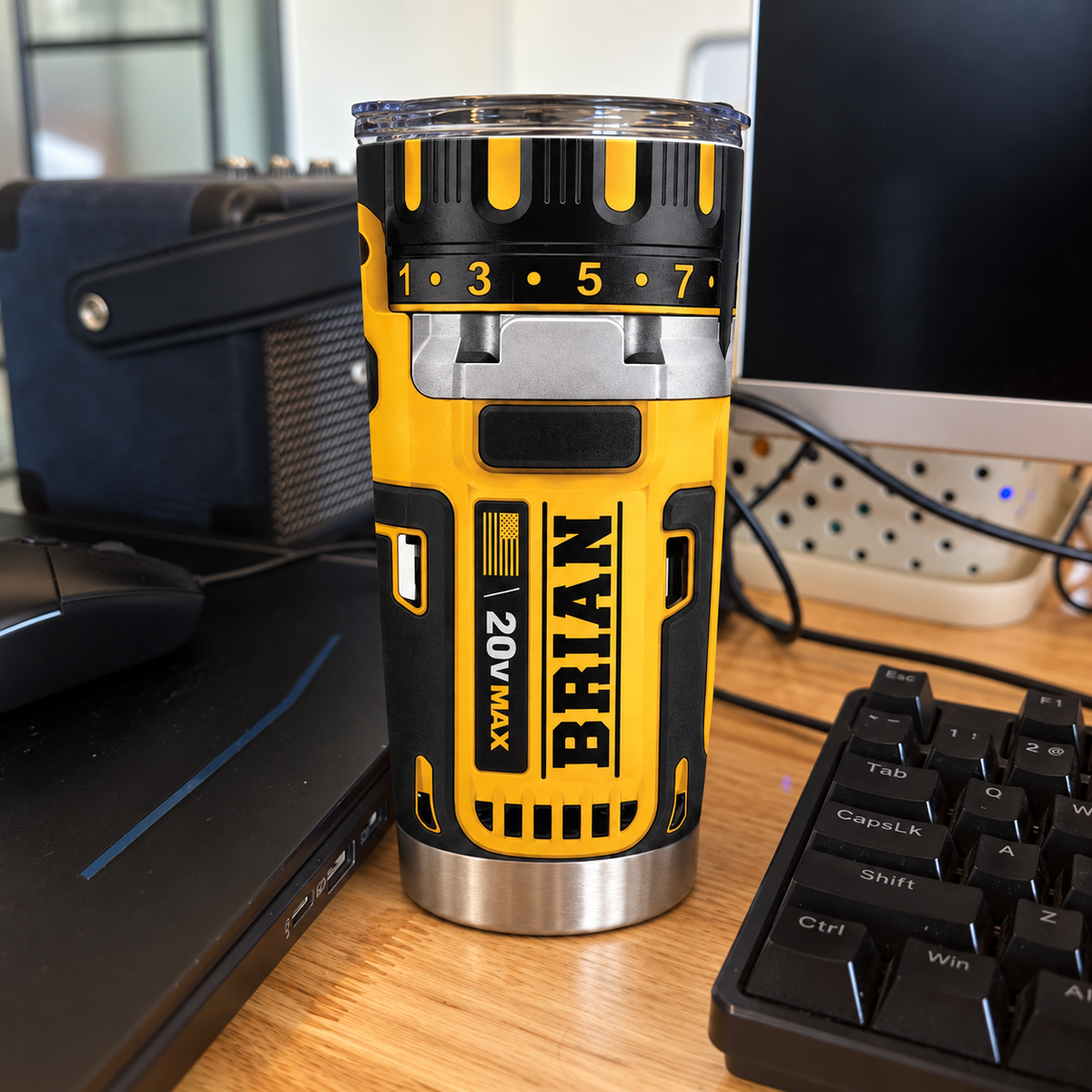 Drill theme stainless steel insulated cup with name BRIAN sitting on a wooden desk next to a computer keyboard and mouse.