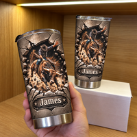A hand holding a personalized western rodeo gift tumbler with a bucking bull design, with another cup on a box behind it.
