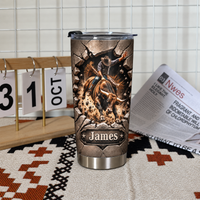 A personalized western rodeo gift tumbler standing on a patterned fabric mat next to a desktop calendar and newspaper.