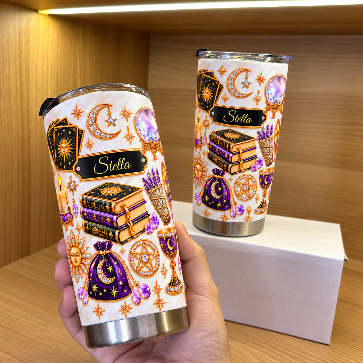 A hand holding a personalized celestial witch tumbler with tarot book gift art.