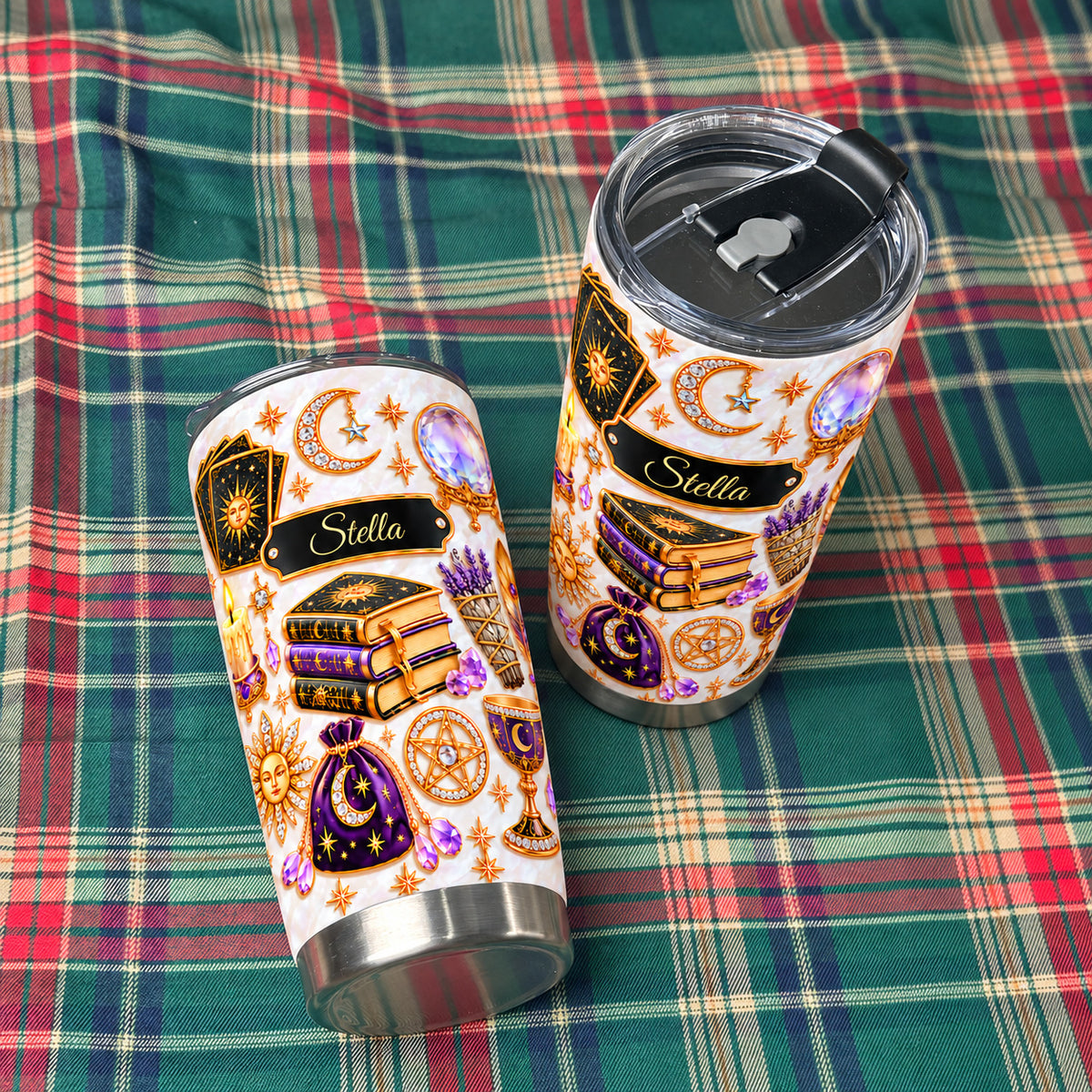 Two personalized celestial witch tumblers resting on a red and green plaid fabric.