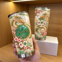 Hand holding a personalized Chinese Dragon Mahjong Jade Tumbler in front of a shelf and gift box.