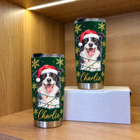 A green stainless steel tumbler featuring a watercolor Border Collie wearing a Santa hat and Christmas lights on a wooden