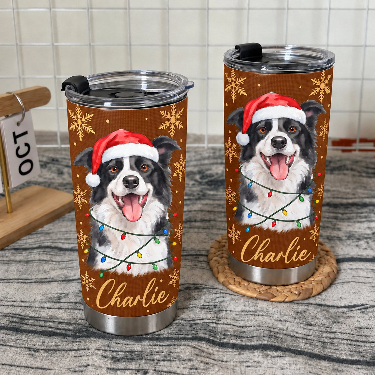 Two personalized stainless steel tumblers with a black and white Border Collie wearing a Santa hat and Christmas lights on