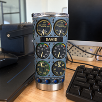Cockpit instrument panel tumbler with custom name David placed on a wooden desk beside a computer keyboard.