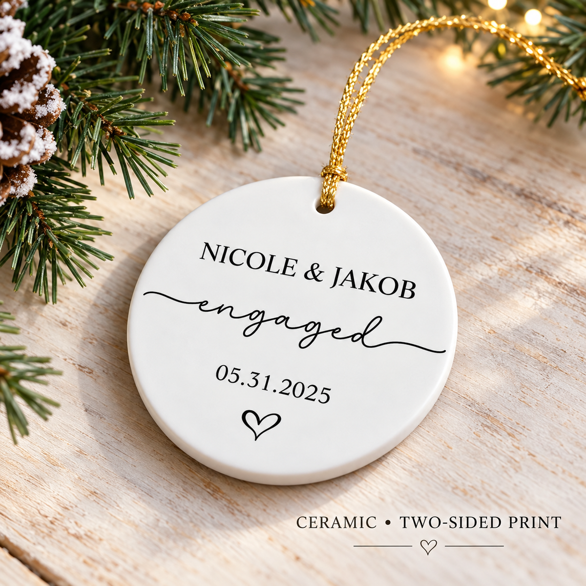Round white ceramic ornament featuring custom text and a gold hanging loop on a rustic wooden surface with pinecones.