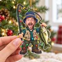 Hand holding the clear acrylic bass fishing gift in front of a softly lit Christmas tree.