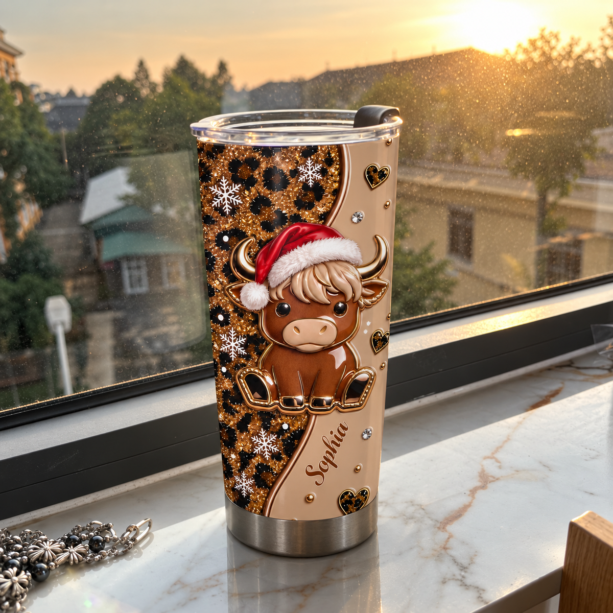Christmas highland cow leopard print tumbler featuring name Sophia standing on marble windowsill at sunset with town view.