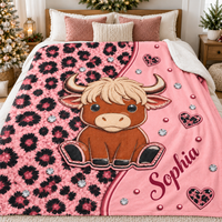 A pink highland cow blanket displayed on a made bed with holiday decor in the background.