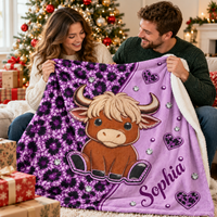 A smiling couple holds up a custom plush sherpa blanket featuring a cute cartoon highland cow, purple leopard print, and the