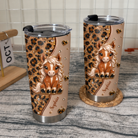 Two personalized horse tumblers with cute pony and leopard print design standing on textured surface next to wooden calendar