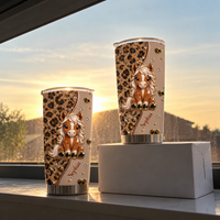 Two personalized horse tumblers of different sizes with cute pony and leopard print standing on windowsill at sunset.