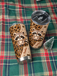 Two personalized animal lover tumblers lie on a green plaid blanket next to a tiny decorative pine tree.