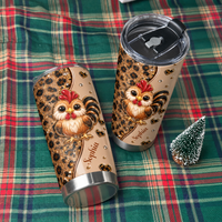Two personalized chicken cups with leopard print and cute roosters lying on a red and green plaid fabric surface.