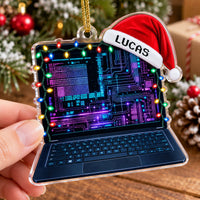 Close-up of the acrylic tech ornament held in hand, showing the neon circuit board screen and Santa hat.
