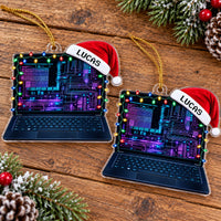 Two flat acrylic laptop ornaments on a wooden surface, featuring neon circuit screens, string lights, and Santa hats