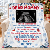 White flannel blanket featuring a baby ultrasound and holiday poem draped over an armchair.