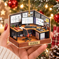 Close-up of the Design Build Iterate ornament held in hand, showing a flat printed office cubicle scene with custom